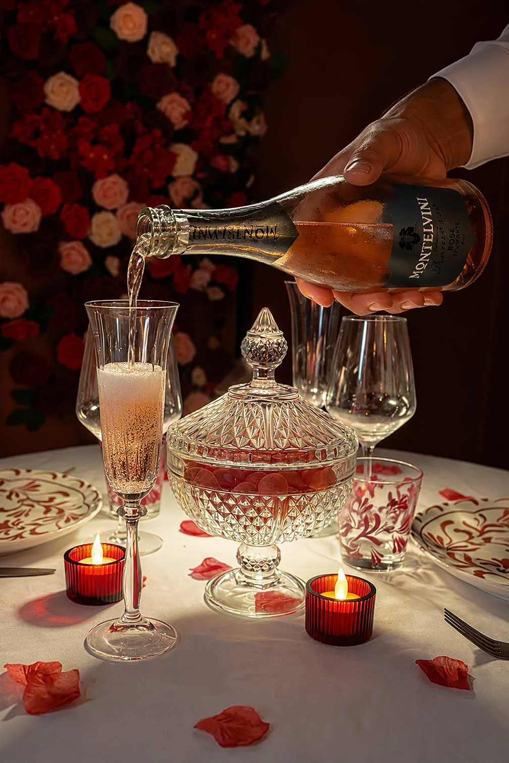 Le service d’un vin pétillant devant le mur de roses
